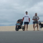 two boys in stroller, Alan, Ken Bob, Mr. Bill (hanging from Kay's leash, and Kay playing Tug 'O' war with leash