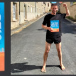 Sylvain Griot (translator) standing barefoot on street, holding copy of the book Barefoot Running Step by Step translated to French