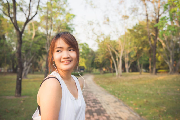 Woman in white tank-top standing outdoors