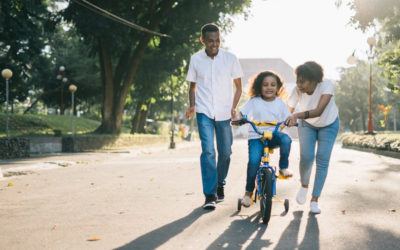 Couple teaching child how to ride a bicycle